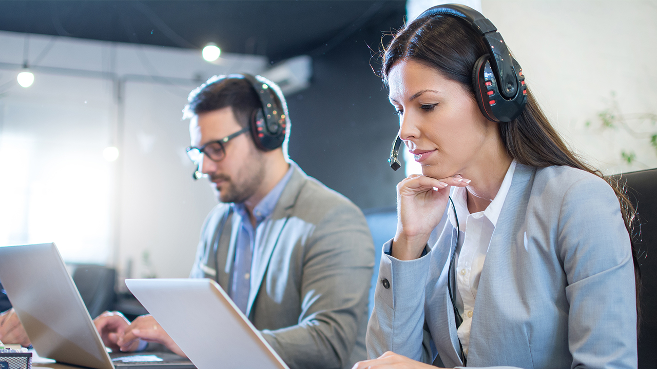 BPO customer service agents working on laptops in a modern call center—illustrating scaling challenges and support solutions