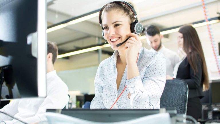 Smiling agent woman with headsets. Portrait of call center worker at office.